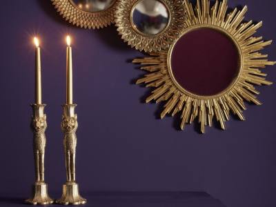 Espejos redondos con marcos dorados y dos candelabros también dorados.