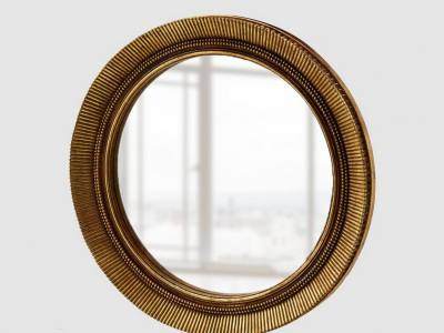 Espejo redondo con marco dorado.